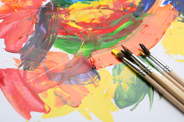 Obraz premium Set of brushes with different paints on artwork. Space for text