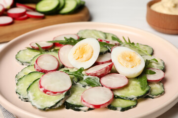 Tasty fresh salad with cucumber on white table, closeup