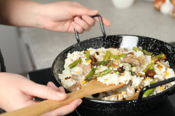 Woman cooking delicious risotto, closeup. Tasty recipe