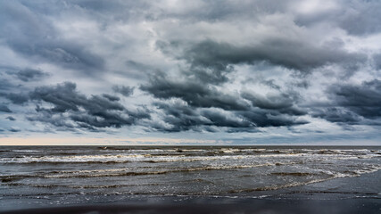 Waves on the sea beach on a cloudy rainy day