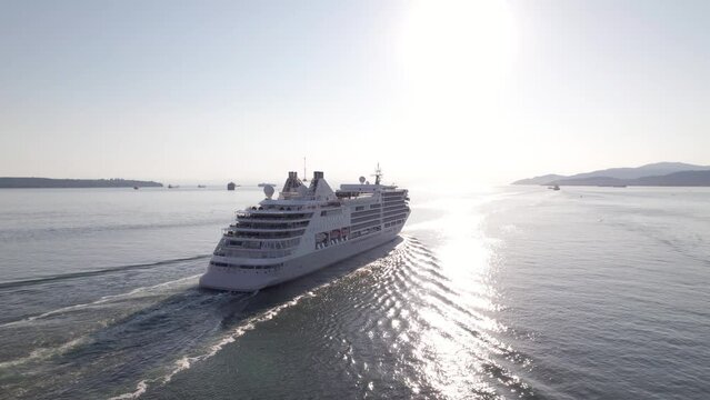 Cruise ship sailing out of Vancouver harbour at sunset, cruise line, large boat, luxury cruise, aerial footage. 4K 4096x2304 24FPS.