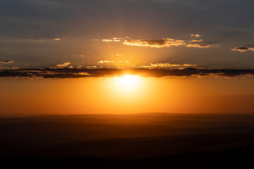 Sunset with few clouds. View from Feldberg mountain in Hessen, Germany. Wide landscape with hills and clouds during sun goes down.