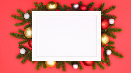 White copy space frame surrounded with gold and red Chrsitmas balls and fir branches. FLat lay WInter holidays concept