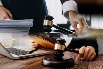 Business and lawyers discussing contract papers with brass scale on desk in office. Law, legal services, advice, justice and law concept picture with film grain effect