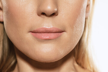 Fototapeta premium Closeup of female lips, cheeks and nose isolated over white studio background. Concept of cosmetology, skincare, cosmetics, plastic surgery, ad