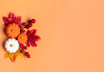 Autumn bouquet of acorns, berries, maple leaves, pumpkins isolated on orange background Flat lay...