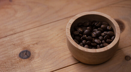 Cup of coffee beans on wood table background, top view