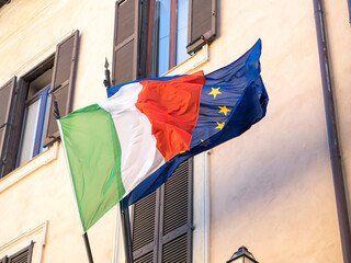 Italian flag and European Union flag flying outside a building in Rome, Italy
