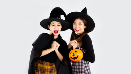 Halloween theme, young asian women in witch costume posing in white background. halloween party...