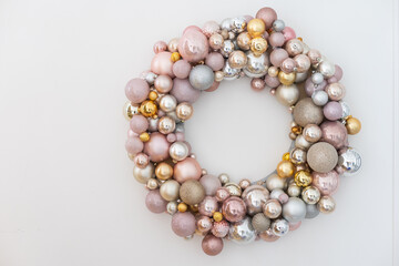 Top view of a large Christmas Wreath made with red ornaments on rustic wood