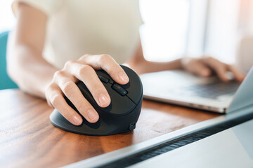 woman hand using computer ergonomic mouse, prevention wrist pain because working long time. De...