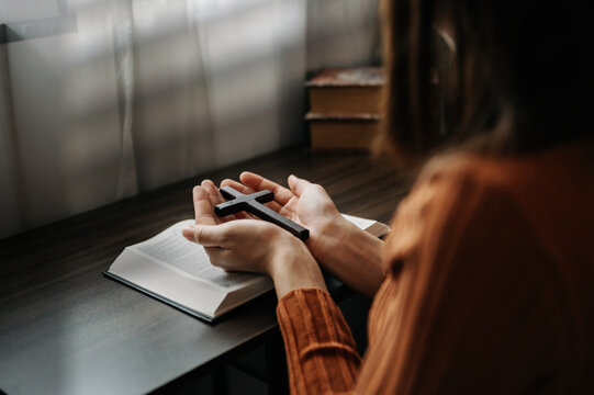 Woman Sitting And Studying The Scriptures.The  Wooden Cross In The Hands. Christian Education Concepts The Holy Scriptures Open And Pray To God