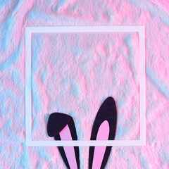 Rabbit Bunny ears with frame on fur background in vibrant gradient holographic neon colors. Minimal flat lay. Christmas or New Year concept.