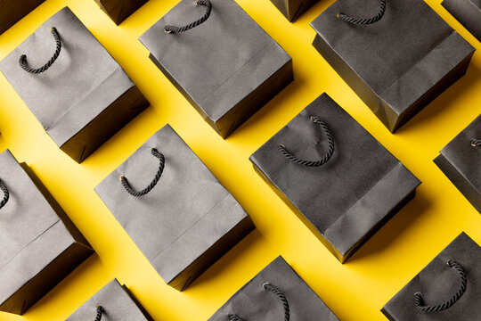 Composition of gray paper shopping bags on yellow background