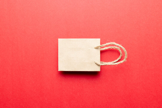 Composition of white paper shopping bag on red background