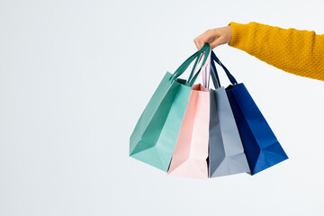 Composition of hand with shopping bags on white background