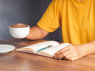 Hand holding a cup of coffee sitting working at the office