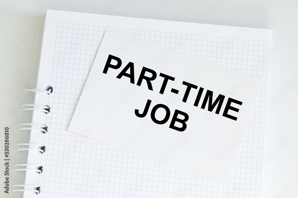 Aufkleber part time job text on a white card that sits on a notepad on a table
