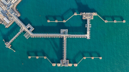 Aerial top view oil terminal station platform with loading arm pipe line on deep seaport, Oil storage terminal port. - obrazy, fototapety, plakaty