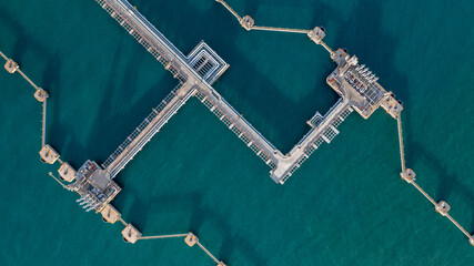 Aerial top view oil terminal station platform with loading arm pipe line on deep seaport, Oil storage terminal port. © Darunrat