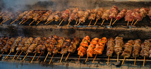inside souvlaki restaurant; two lines of traditional greek skewered meat souvlaki ready to serve    