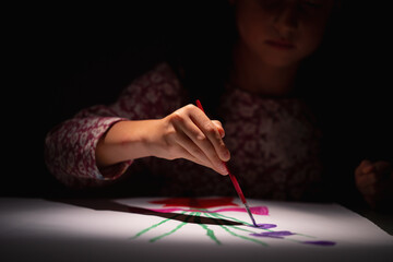 Happy young girl in art studio painting picture. Selective focus on eyes of child. Selective focus on hand. Horizontal image.