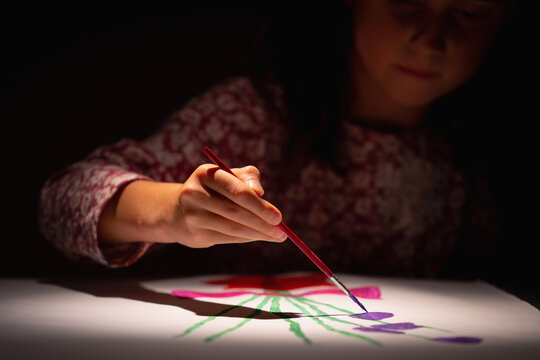 Hobby, art and childhood concept. Happy young girl learn to draw. Selective focus on hand. Horizontal image.