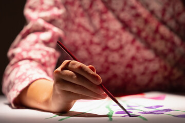 Happy young girl learn to draw. Selective focus on hand.