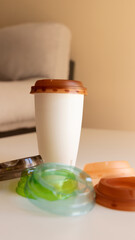 a coffee to go on the table with caps of different colors