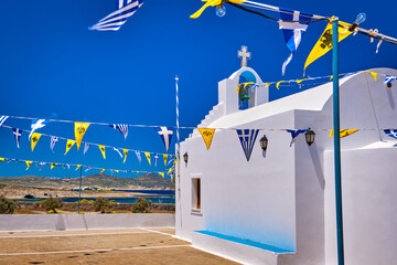 White Greek Orthodox chapel or church on top of hill against clear