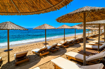 Rows of sun umbrellas and sunbeds ready for tourists on sandy beach