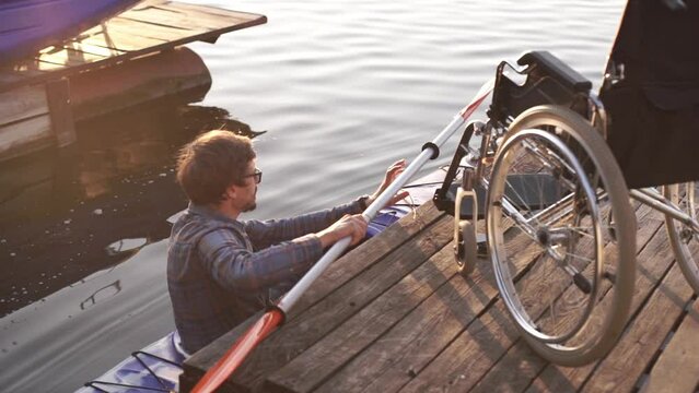 A man with a disability is kayaking against the backdrop of a golden sunset. Unity with the harmony of nature