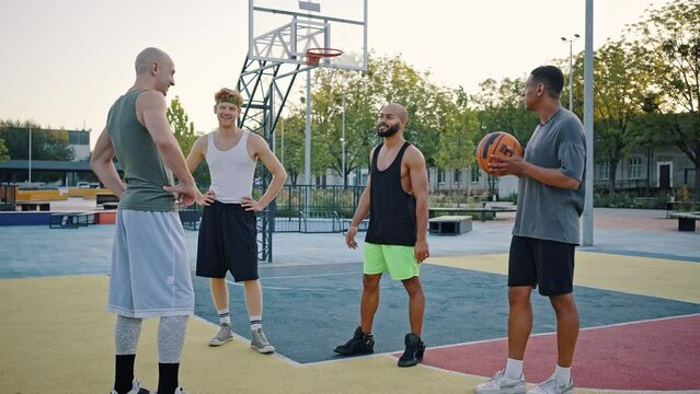 Men determine teams standing on outdoor court with ball