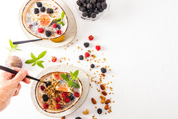 a woman's hand holds a spoon filled with delicious homemade healthy granola. healthy clean food. Fitness. top view.