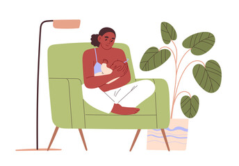 Woman breastfeeding her baby while sitting in armchair at home