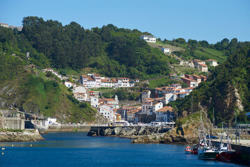 Fototapeta na wymiar Cudillero, Asturias, Spain; June 16, 2022; A beautiful sea view on the coast of Cudillero. Cliffs of northern Spain.Lighthouse access to the port of Cudillero, Asturias.