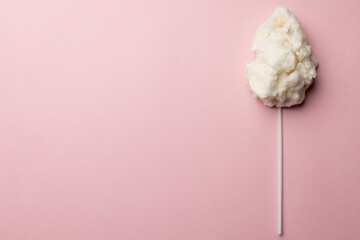 Horizontal image of homemade white candy floss on stick, on pink background with copy space