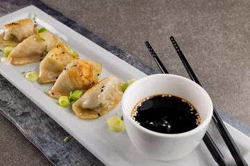 Foto op Aluminium Close up of dumplings, soy sauce and chopsticks on grey background © vectorfusionart