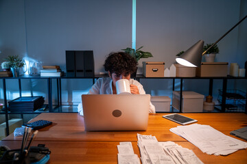 woman working at home at night after work using notebook happily