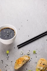 Foto op Aluminium Overhead view of asian dumplings, soy sauce and chopsticks on grey background © vectorfusionart