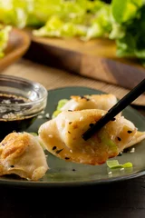 Foto op Aluminium Close up of asian dumplings, soy sauce and chopsticks on plate on wooden background © vectorfusionart