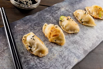 Foto op Aluminium Close up of asian dumplings, soy sauce and chopsticks with slate and wooden background © vectorfusionart
