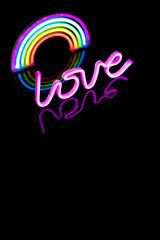 Image of vibrant neon love text and glow sticks forming rainbow over black background and copy space