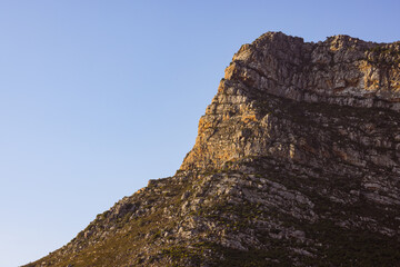 Landscape of rocky mountains with scarce plants against cloudless blue sky