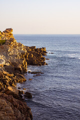 Fototapeta na wymiar Landscape of sea waves and sea shore with rocks, blue cloudless sky and horizon