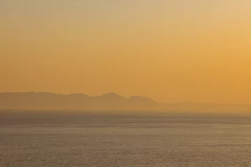 Poster de jardin Mer / coucher de soleil Paysage de mer, bord de mer avec montagnes, ciel sans nuages au coucher du soleil et à l& 39 horizon