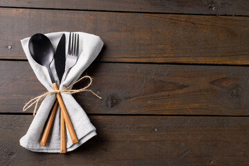 Overhead view of cutlery, rustic string and napkin with copy space on wooden background