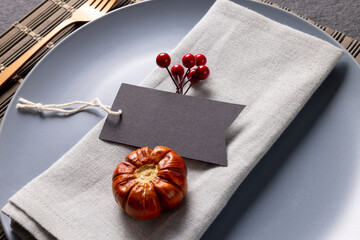 Close up of thanksgiving place setting with tag and autumn decoration on slate