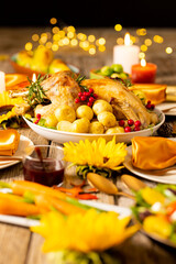 Fototapeta na wymiar Close up of thanksgiving table with roast turkey, potatoes, candles and autumn decoration