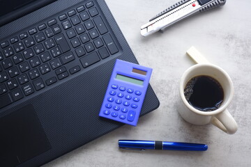 コーヒーを飲みながらノートパソコン（黒）で仕事をする